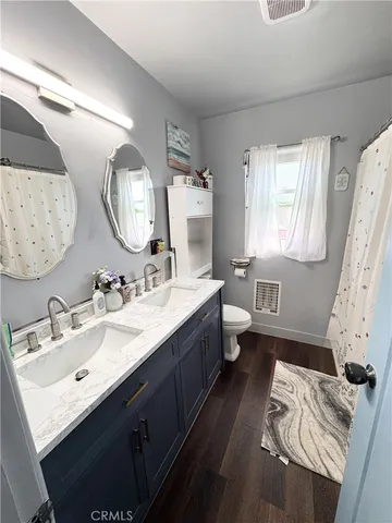 a bathroom with a double vanity sink mirror and toilet