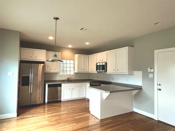 a kitchen with stainless steel appliances granite countertop a refrigerator a sink and a stove