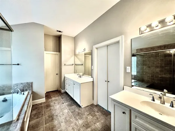 a bathroom with a tub sink and mirror