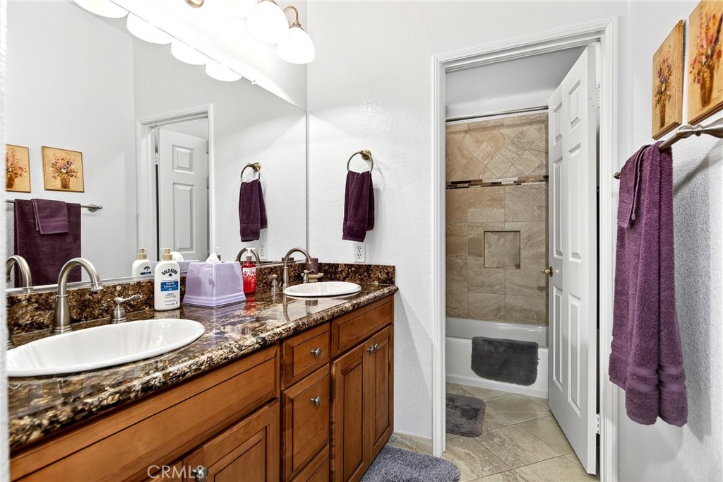 7619 Vista Rio Road Highland, CA 92346 - Photo 19 of 25 a bathroom with a granite countertop sink a mirror and shower