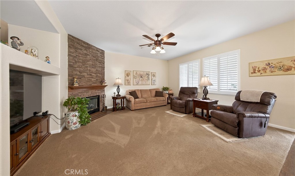 7619 Vista Rio Road Highland, CA 92346 - Photo 10 of 25 a living room with furniture a fireplace and a flat screen tv