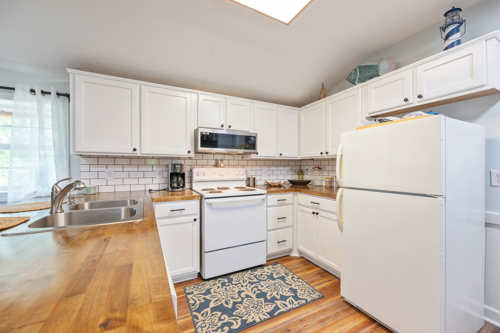 91 Creekside View Lane Decaturville, TN 38329 - Photo 9 of 57 a kitchen with white cabinets and white appliances