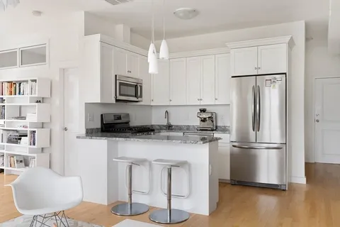 a kitchen with stainless steel appliances granite countertop a refrigerator and a stove top oven