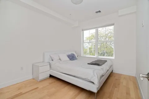 a bed sitting in a bedroom next to a window