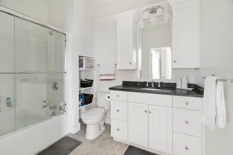 a bathroom with a bathtub shower sink vanity and toilet