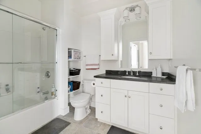 a bathroom with a bathtub shower sink vanity and toilet