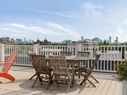 a view of a roof deck with table and chairs
