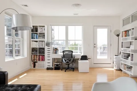 a view of a livingroom with workspace and a window