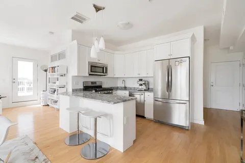 a kitchen with stainless steel appliances granite countertop a refrigerator stove and sink