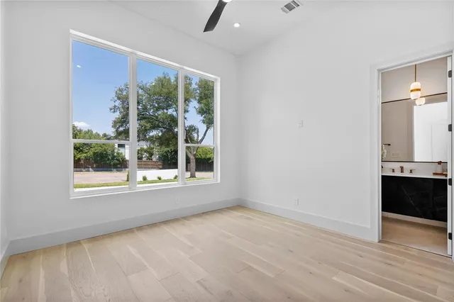 an empty room with wooden floor and a window