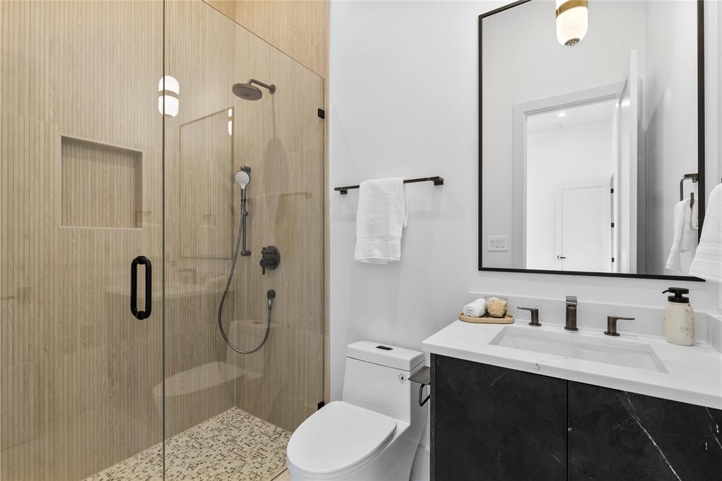 11232 Hillcrest Road Dallas, TX 75230 - Photo 30 of 40 a bathroom with a sink vanity granite toilet and shower