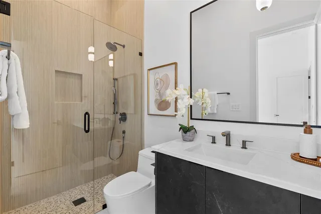 a bathroom with a sink a toilet and shower