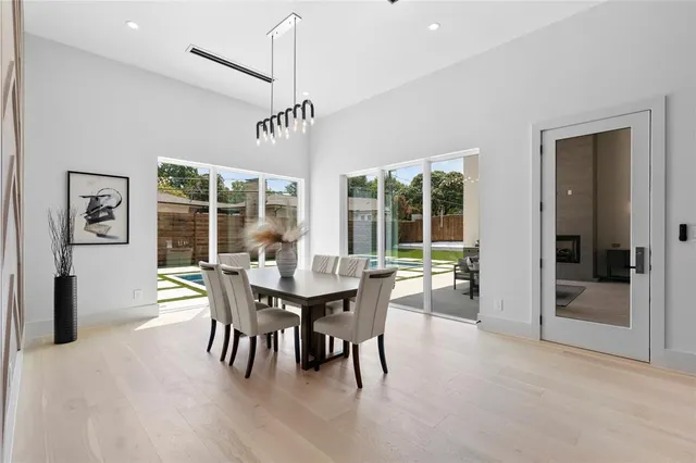a dining room with furniture a chandelier and wooden floor