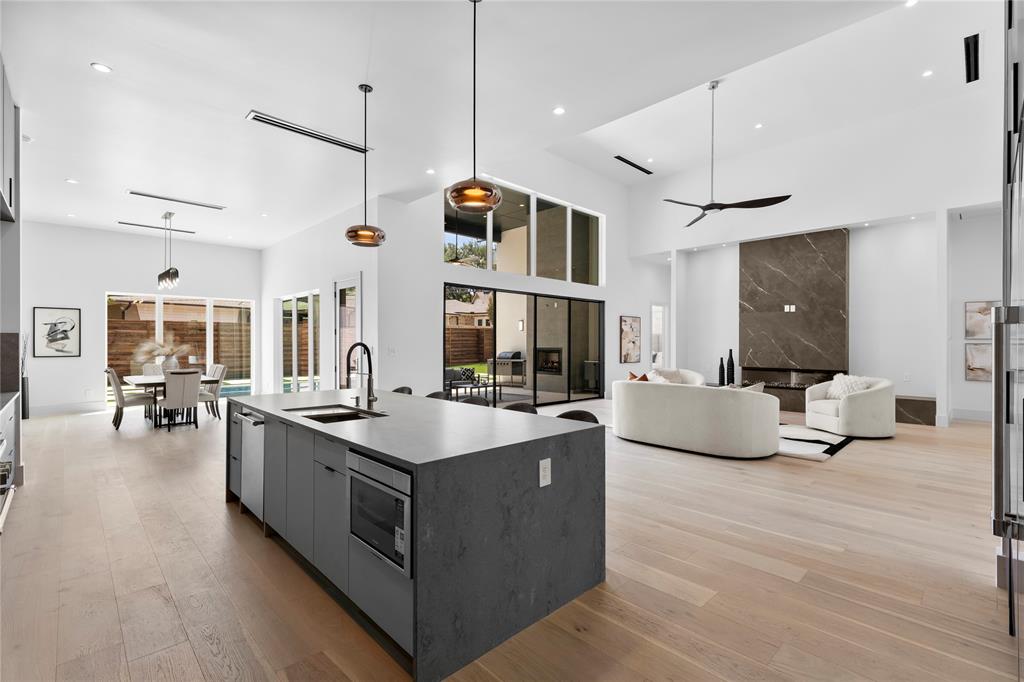 11232 Hillcrest Road Dallas, TX 75230 - Photo 40 of 40 a large kitchen with stainless steel appliances kitchen island a large counter top a stove and a wooden floors