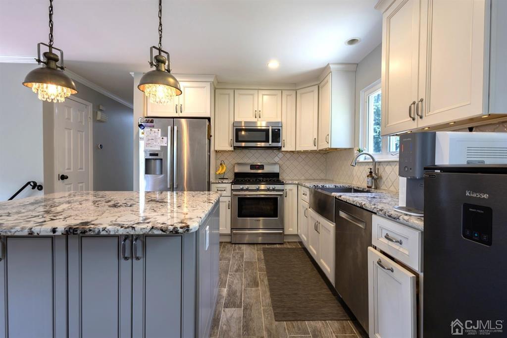 53 Edgemere Avenue Plainsboro, NJ 08536 - Photo 3 of 39 a kitchen with granite countertop a stove a sink and a refrigerator