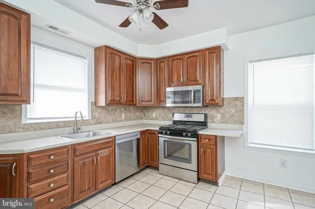 a kitchen with a stove sink cabinets and window