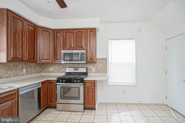 a kitchen with white cabinets a sink and a stove with wooden floor