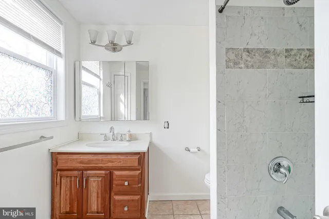 a bathroom with a granite countertop sink a mirror and a window
