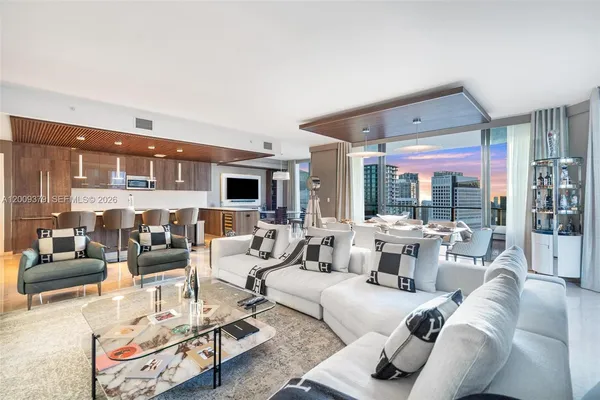 a living room with furniture large window and glass table