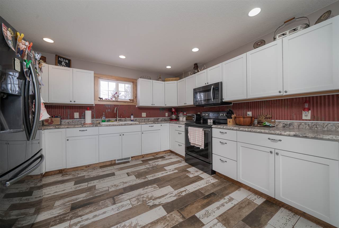1785 Willow Road Franklin Grove, IL 61031 - Photo 13 of 38 a kitchen with granite countertop white cabinets and stainless steel appliances