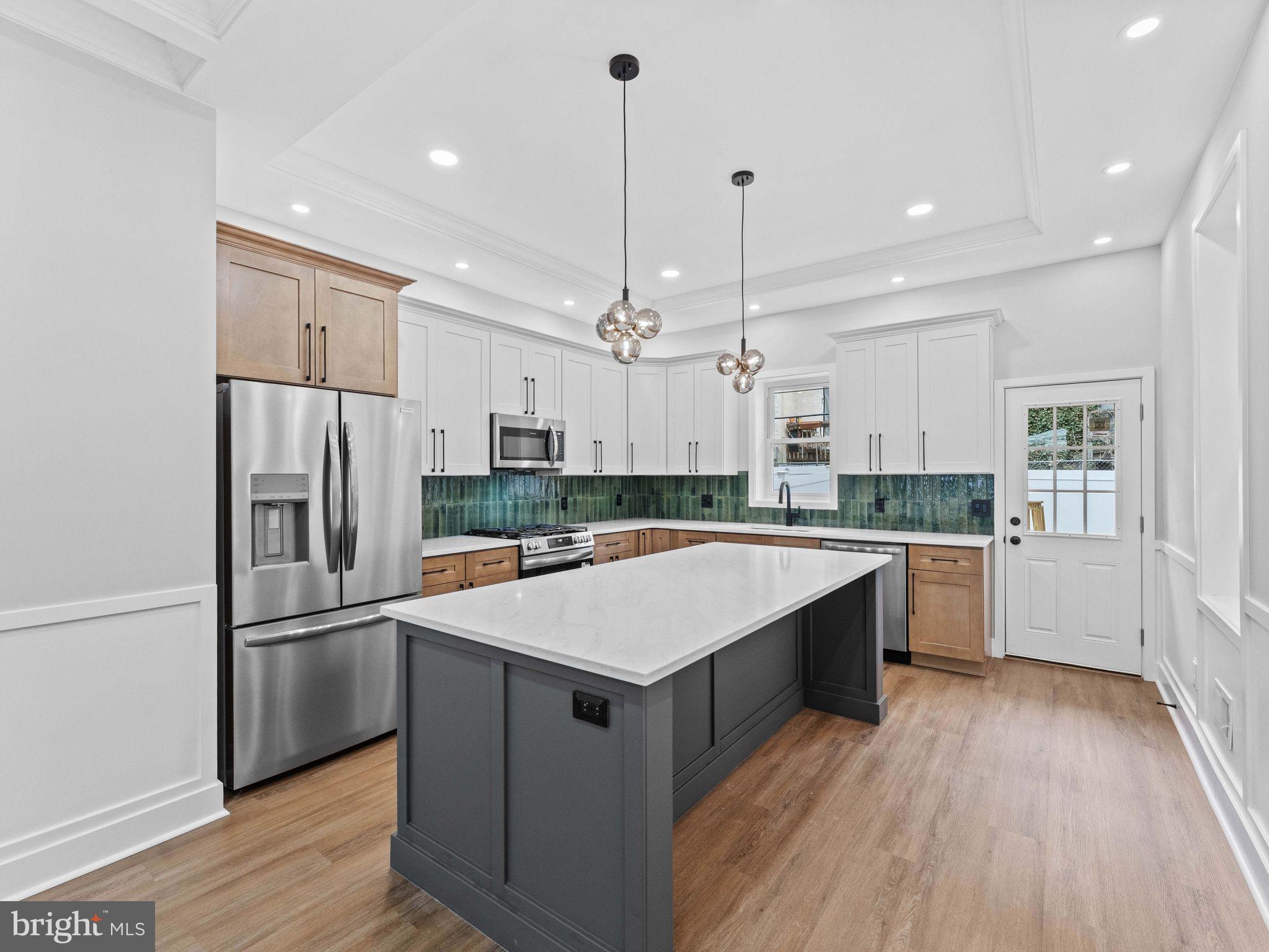 138 West Sharpnack Street Philadelphia, PA 19119 - Photo 14 of 44 a large kitchen with a center island wooden floor and stainless steel appliances