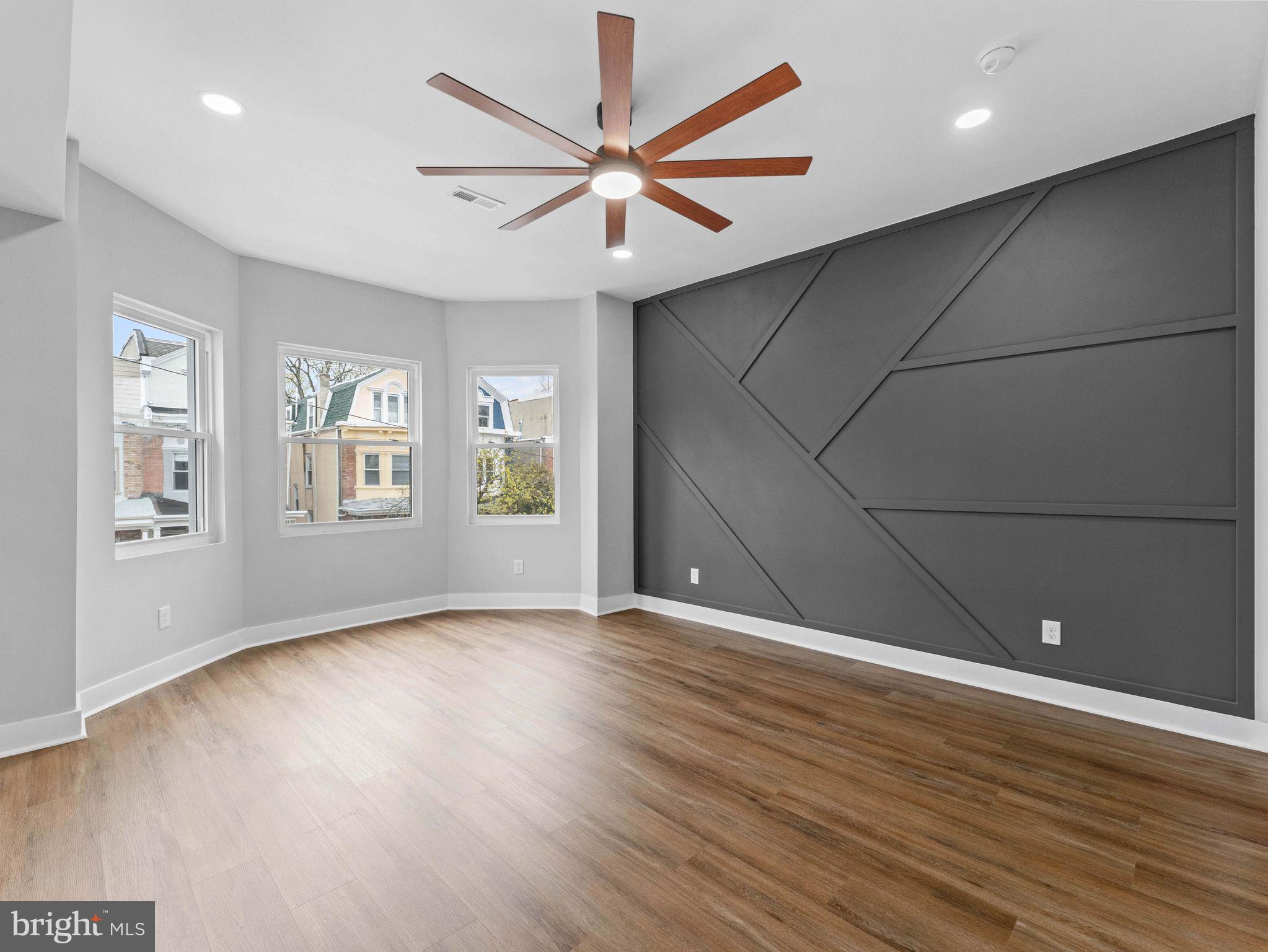 138 West Sharpnack Street Philadelphia, PA 19119 - Photo 22 of 44 an empty room with wooden floor chandelier fan and windows