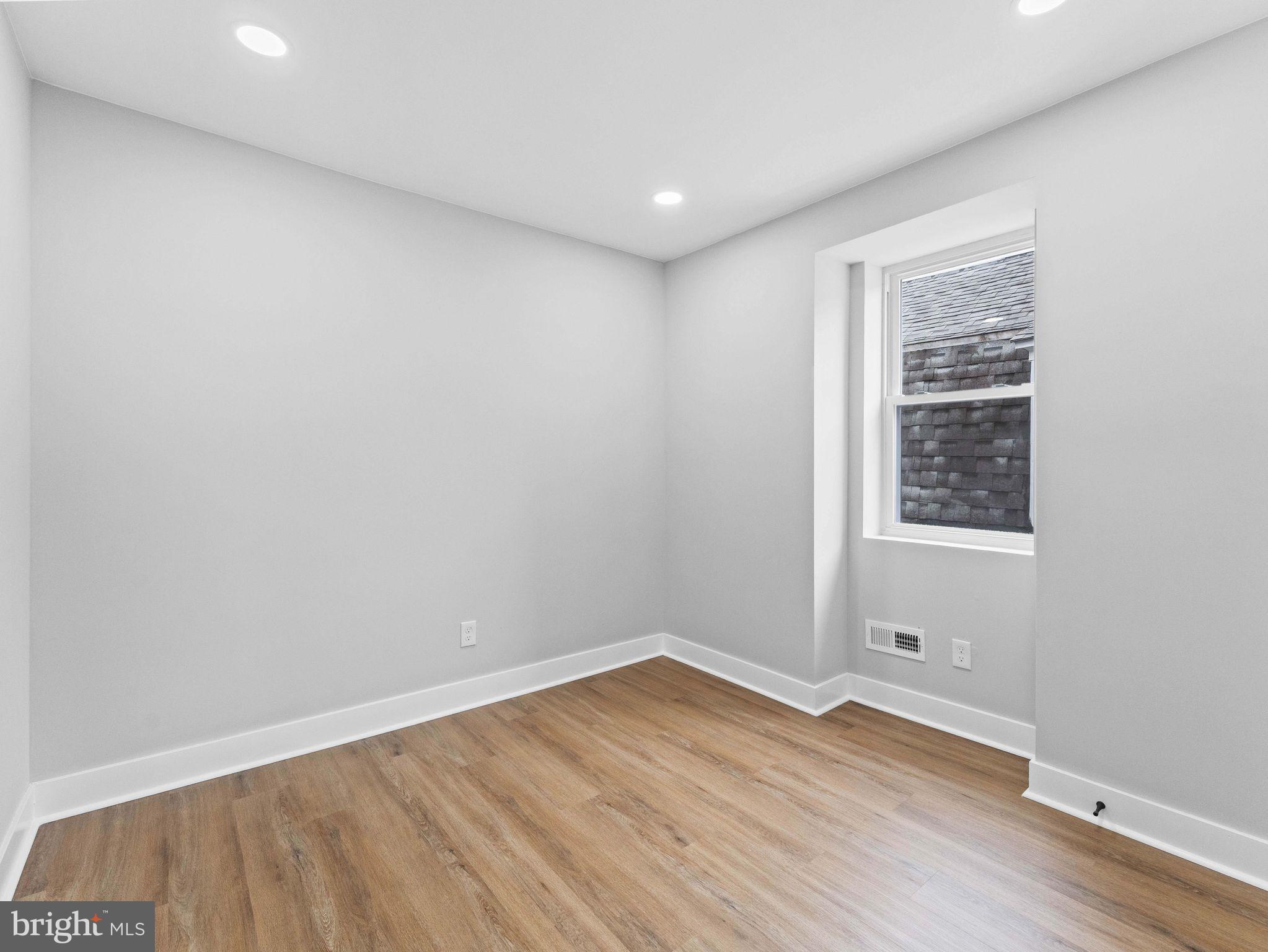 138 West Sharpnack Street Philadelphia, PA 19119 - Photo 35 of 44 a view of an empty room with wooden floor and a window