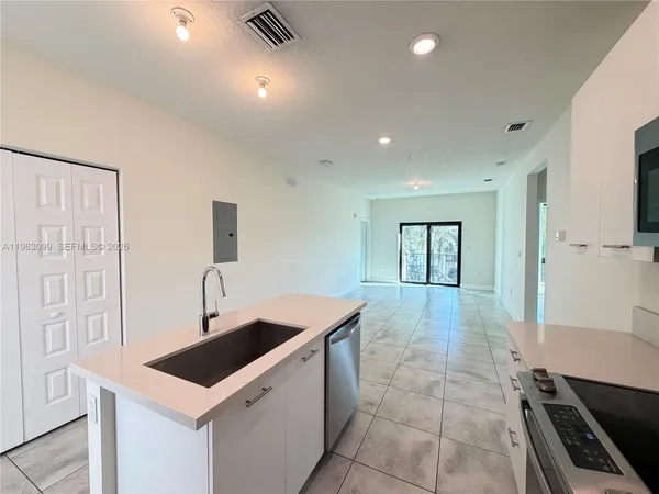a kitchen that has a sink a stove and a microwave oven in it