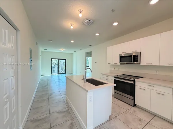 a kitchen with stainless steel appliances granite countertop a sink and dishwasher a stove top oven with wooden floor