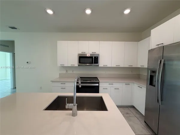 a kitchen with granite countertop a refrigerator and a stove