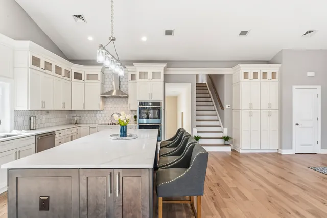 a kitchen with a table chairs refrigerator and microwave