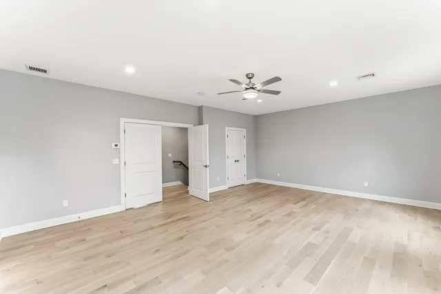 a view of an empty room with wooden floor