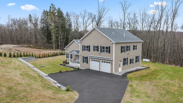 a view of a house with backyard and trees