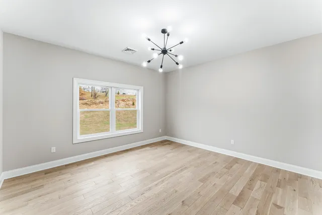 a view of a livingroom with a ceiling fan and wooden floor