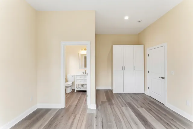 a bathroom with a toilet a sink a mirror and a window