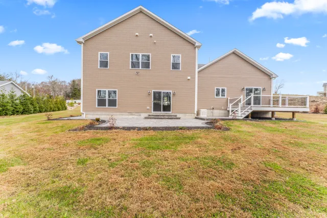 a front view of house with yard and trees in the background