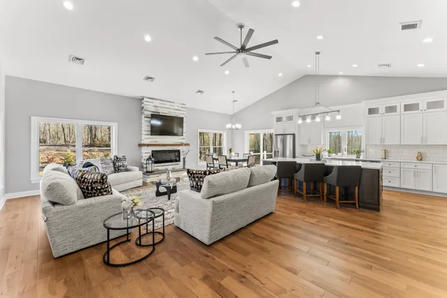 a living room with furniture kitchen view and a wooden floor