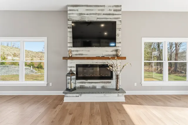 an empty room with wooden floor and a fireplace