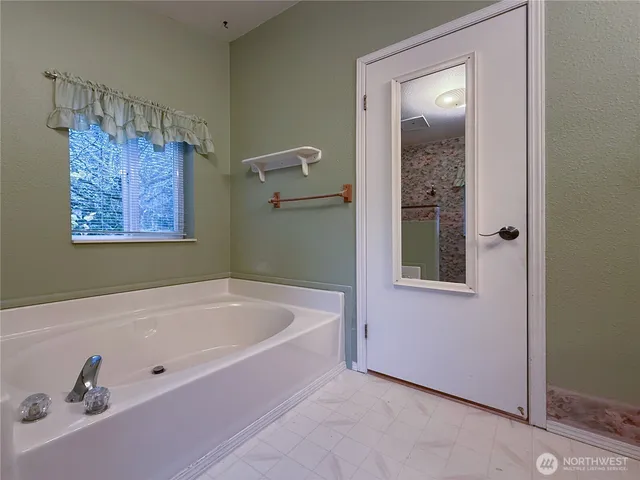 a white bath tub sitting next to a bathroom