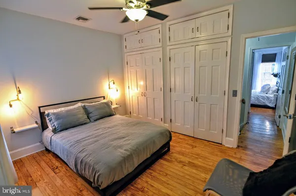 a bedroom with a bed and wooden floor