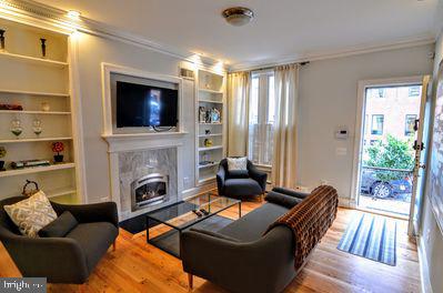 1029 30th Street Northwest Washington, DC 20007 - Photo 5 of 40 a living room with furniture a flat screen tv and a fireplace