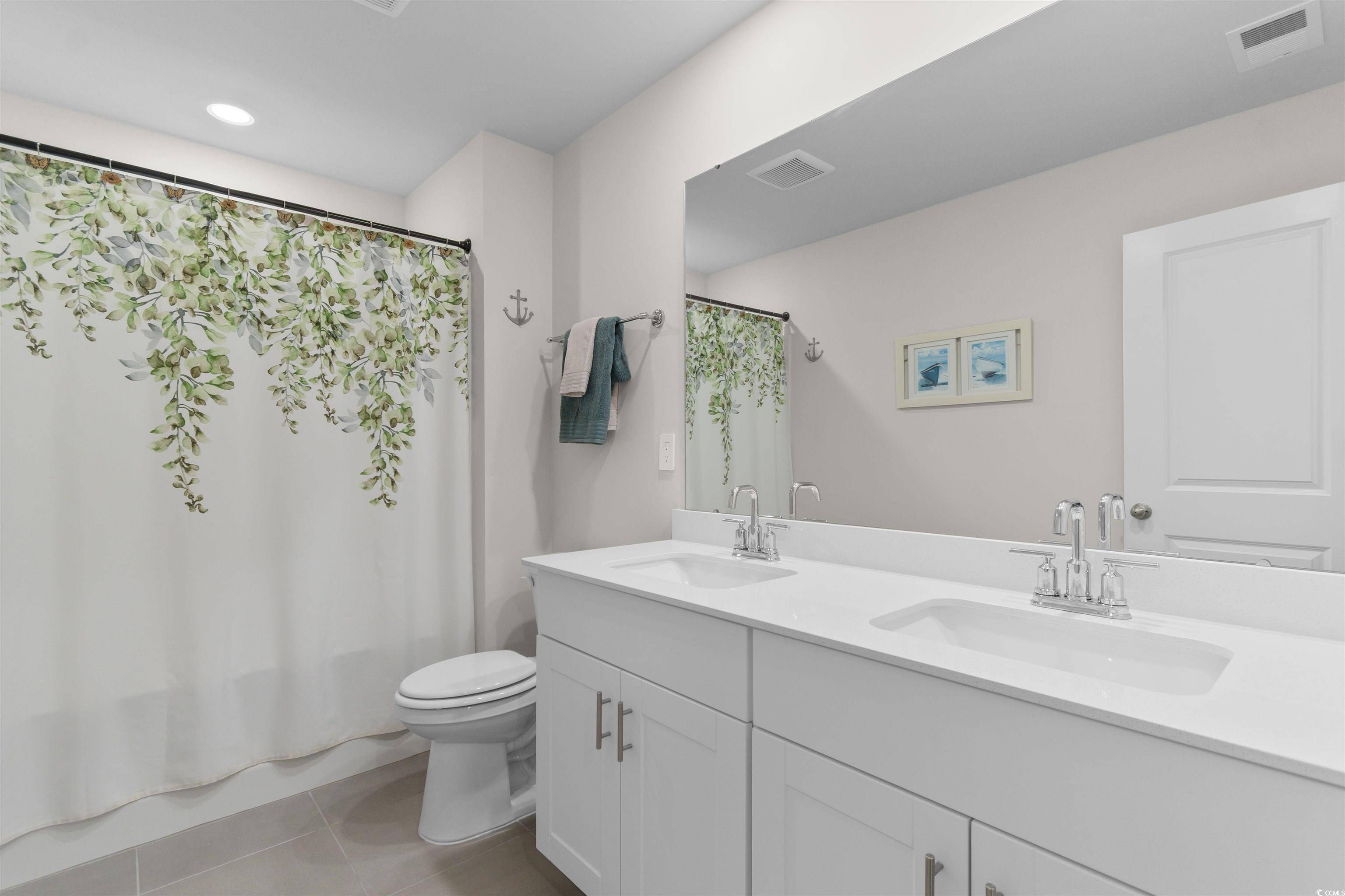 4059 Bayhill Street Myrtle Beach, SC 29579 - Photo 23 of 40 Full bathroom featuring double vanity, light tile patterned floors, and shower / tub combo with curtain