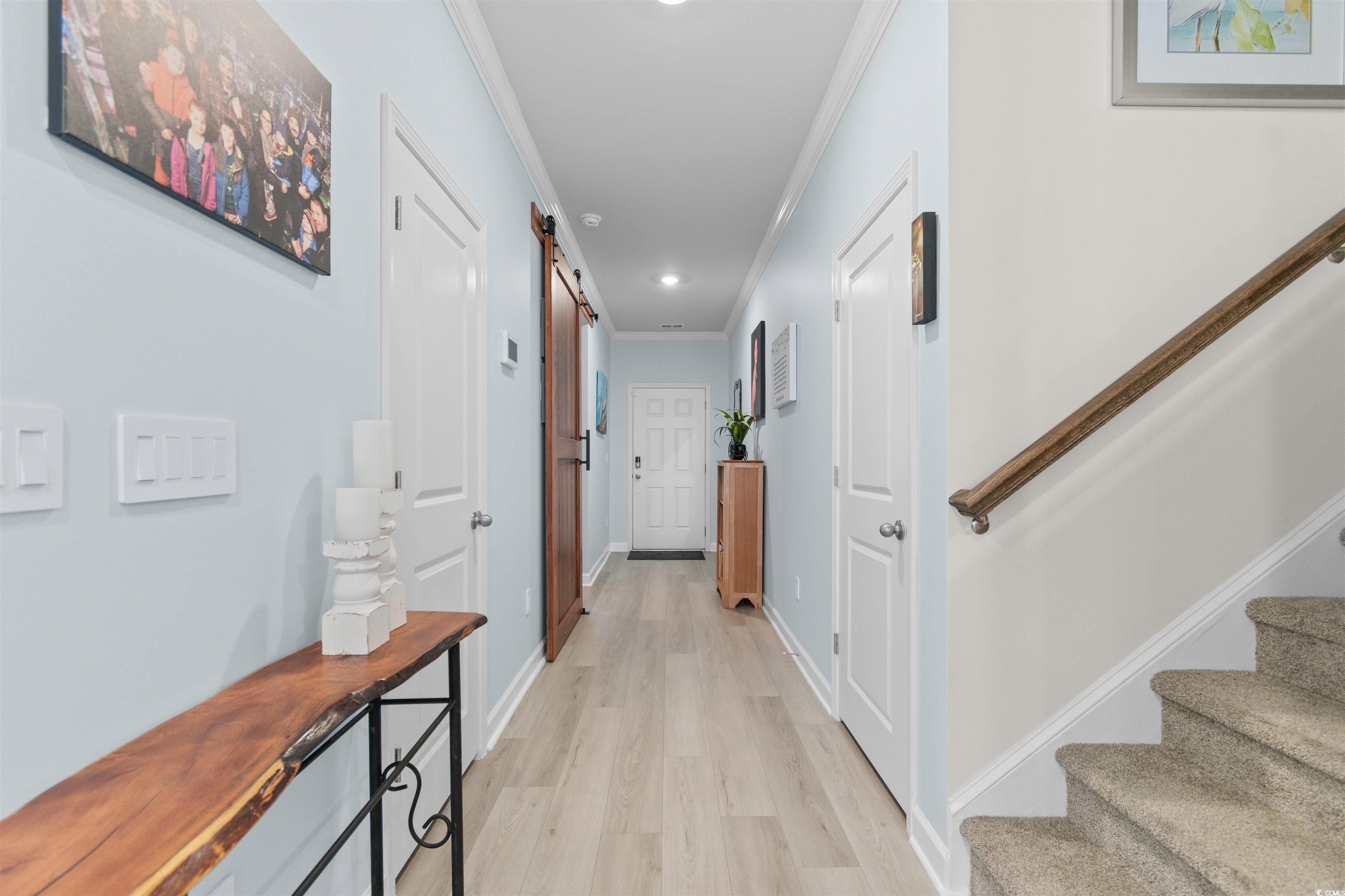 4059 Bayhill Street Myrtle Beach, SC 29579 - Photo 5 of 40 Hallway featuring a barn door, light wood-type flooring, crown molding, stairs, and recessed lighting