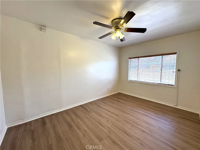 a view of a hallway and wooden floor and a livingroom with furniture
