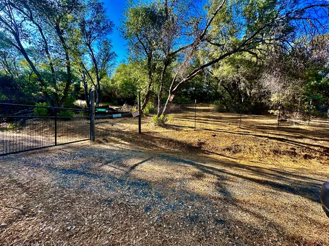 a view of a yard with wooden fence