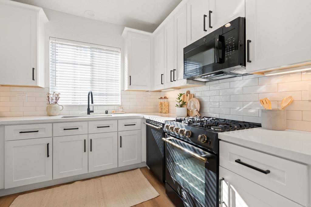 3114 Via Puerta Carlsbad, CA 92009 - Photo 13 of 39 a kitchen with white cabinets stainless steel appliances and sink