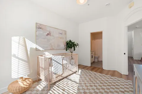 a view of a bedroom with wooden floor