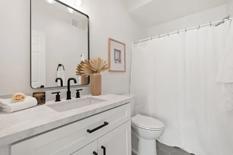 a bathroom with a sink a toilet and mirror