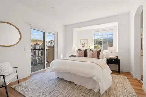 a bedroom with a large bed and a wooden floor