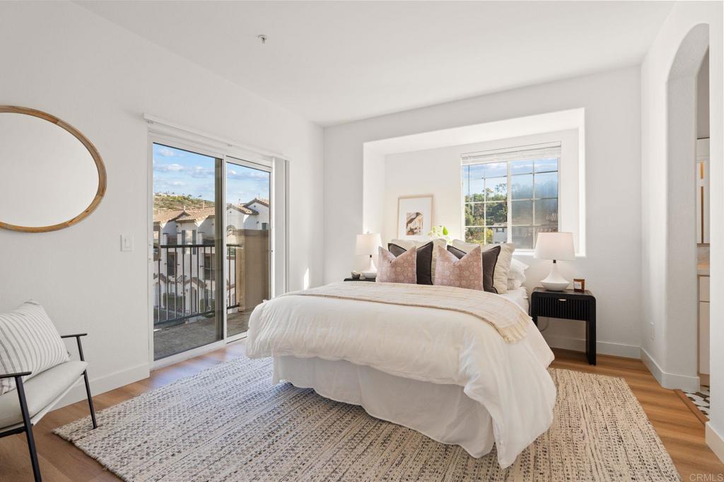 3114 Via Puerta Carlsbad, CA 92009 - Photo 19 of 39 a bedroom with a large bed and a wooden floor